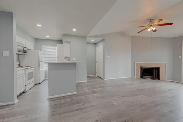 a view of a kitchen with wooden floor and electronic appliances