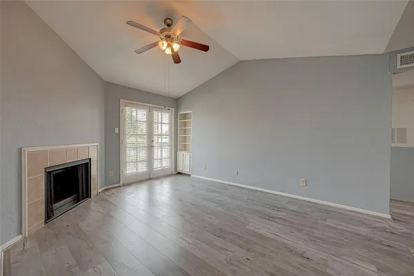 a view of an empty room with a fireplace and a window