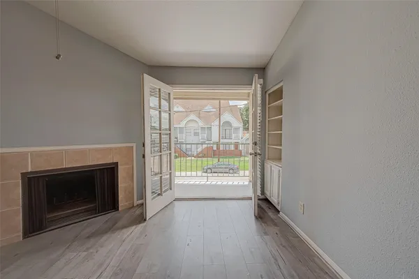 a view of an empty room with a fireplace and a window
