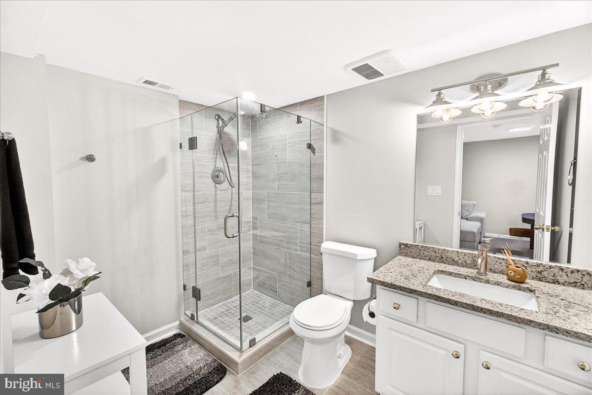 6303 Edgeware Court Frederick, MD 21703 - Photo 38 of 74 a bathroom with a granite countertop sink toilet and shower