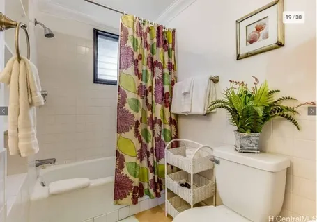 a bathroom with a toilet a sink and a shower curtain