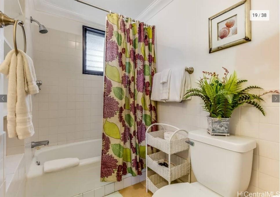 134 Kapahulu Avenue, Unit 518 Honolulu, HI 96815 - Photo 19 of 23 a bathroom with a toilet a sink and a shower curtain
