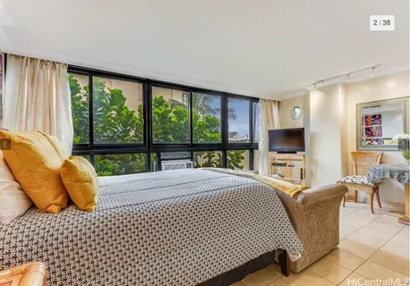 a bedroom with a bed and large windows