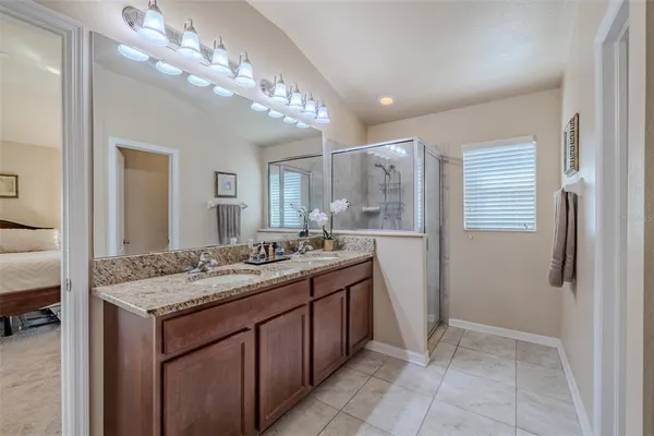 a bathroom with a granite countertop sink a large mirror and a shower
