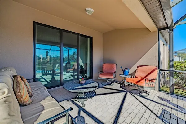 a living room with furniture a rug and a floor to ceiling window
