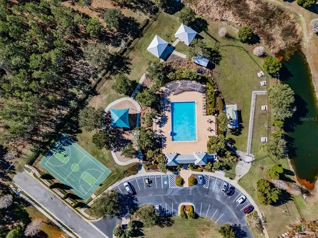 an aerial view of a house with a swimming pool a yard and a fountain