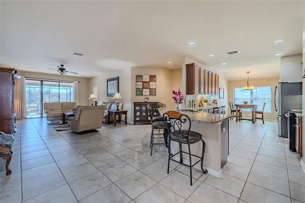 a living room with lots of furniture and a dining table with kitchen view