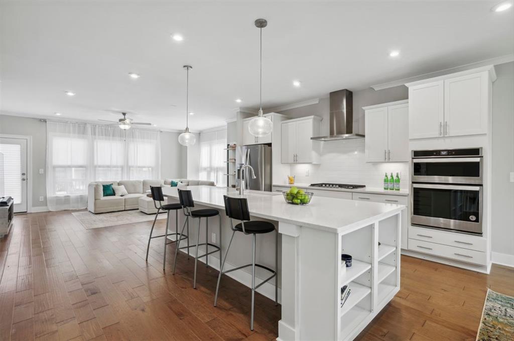 1287 Forsyth Park Road Decatur, GA 30033 - Photo 1 of 1 a kitchen with stainless steel appliances kitchen island granite countertop a stove a sink a oven and a dining table with wooden floor