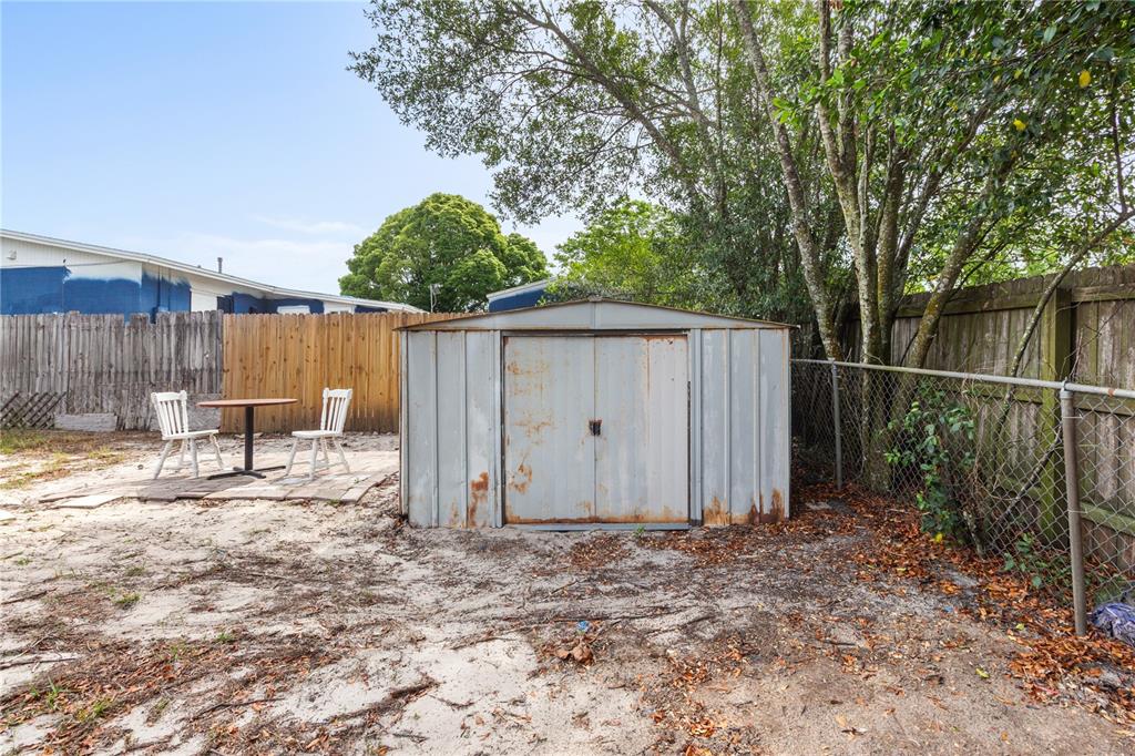 7208 Fair Oaks Street Spring Hill, FL 34606 - Photo 24 of 25 a view of a backyard with large trees and wooden fence
