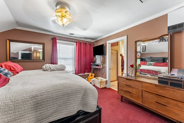 a bedroom with a bed window and flat screen tv