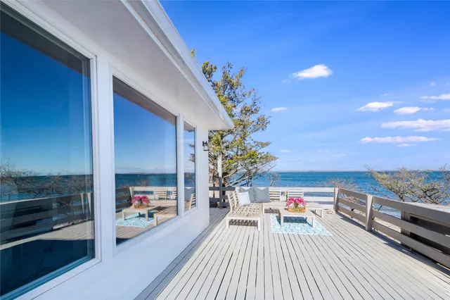 a view of a balcony with dining table and chairs with wooden floor