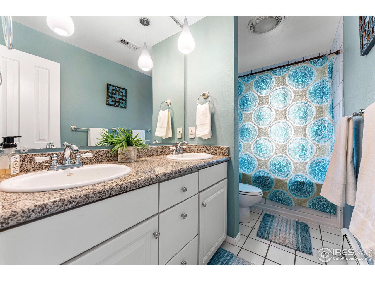 3880 Cloverleaf Drive Boulder, CO 80304 - Photo 21 of 38 a bathroom with a granite countertop sink a toilet a mirror a vanity and shower