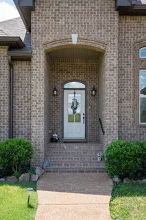 a front view of a house with a garden and plants