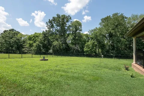 an aerial view of a house with pool big yard and large trees