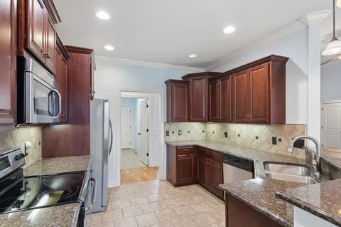 a kitchen with stainless steel appliances granite countertop a sink refrigerator and cabinets