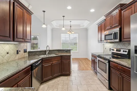 a kitchen with stainless steel appliances granite countertop a sink stove and oven