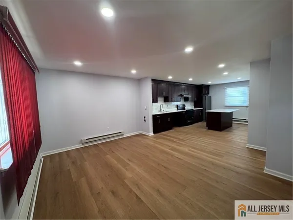 a view of kitchen with refrigerator and windows