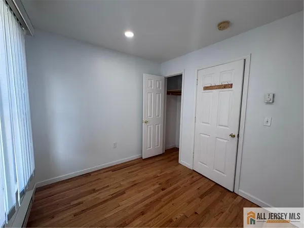 an empty room with wooden floor and closet