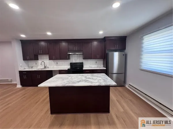 a large kitchen with kitchen island a sink stainless steel appliances and cabinets