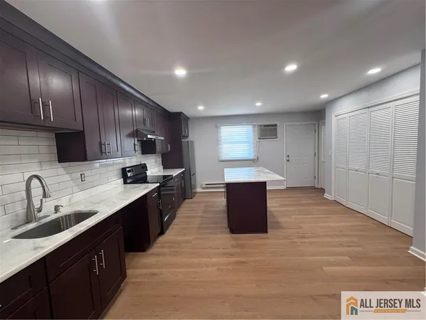 a large kitchen with stainless steel appliances lots of counter space and wooden floor