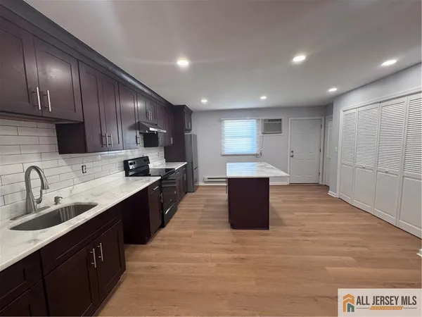 a large kitchen with stainless steel appliances lots of counter space and wooden floor