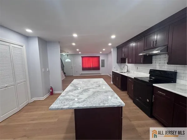a kitchen with stainless steel appliances kitchen island granite countertop a sink counter space and cabinets