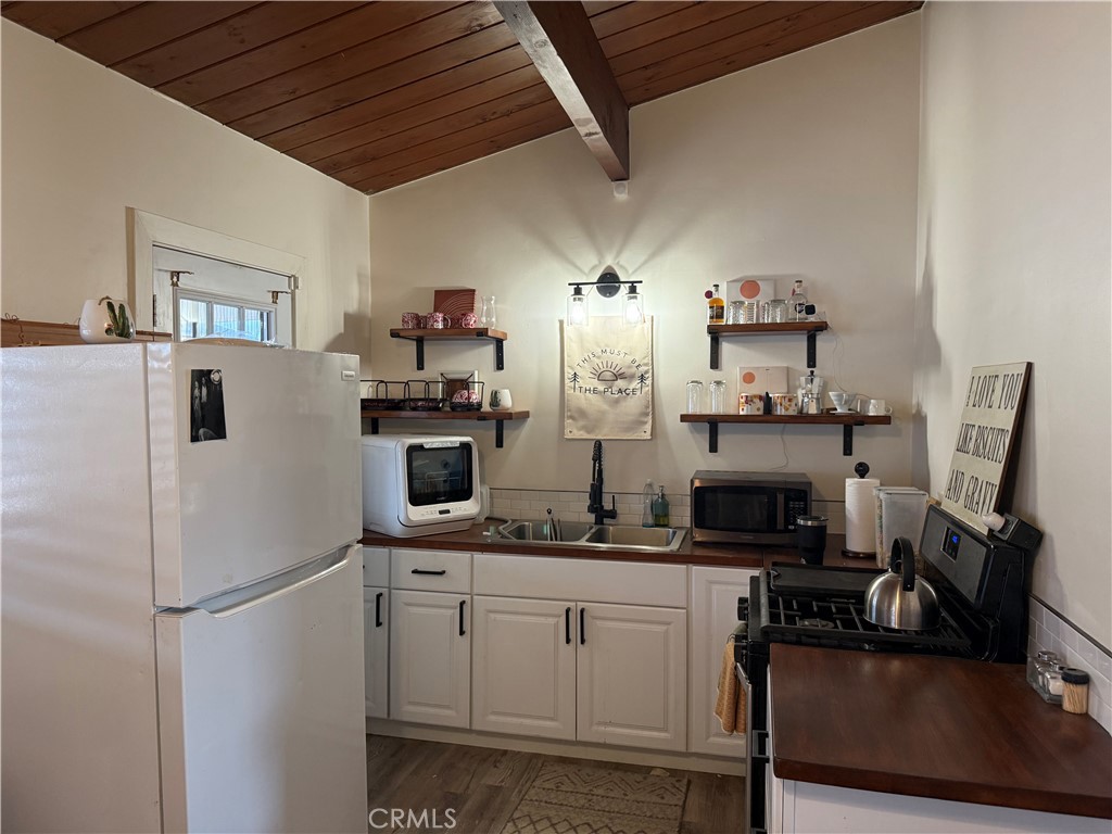 6922 Datura Avenue Twentynine Palms, CA 92277 - Photo 16 of 24 a kitchen with cabinets and refrigerator