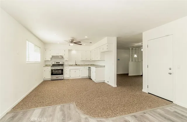a kitchen with granite countertop white cabinets and white appliances