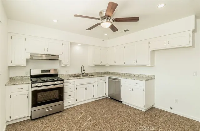 an empty room with a ceiling fan and wooden floor