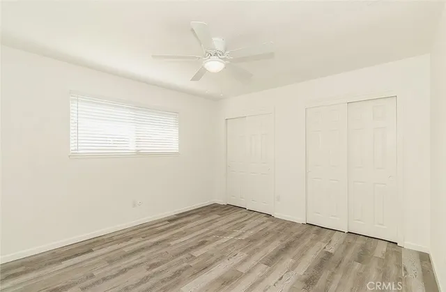 an empty room with a ceiling fan and a window