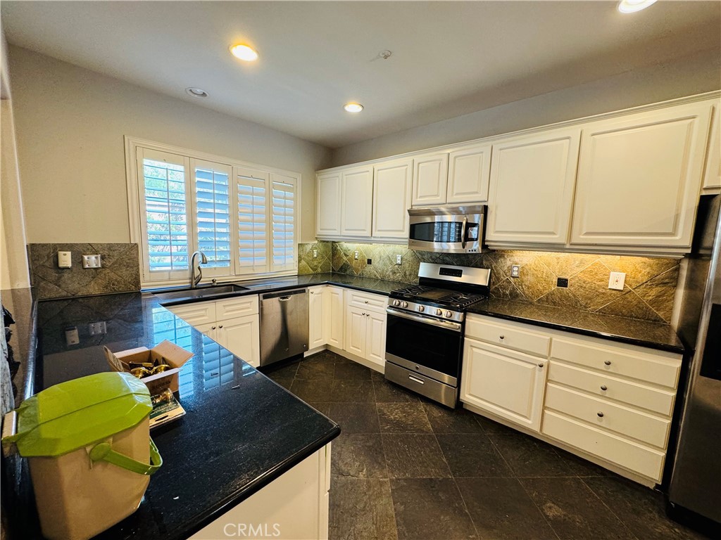3 Bradford Irvine, CA 92602 - Photo 6 of 21 a kitchen with granite countertop kitchen island stainless steel appliances a stove a sink a counter space and cabinets