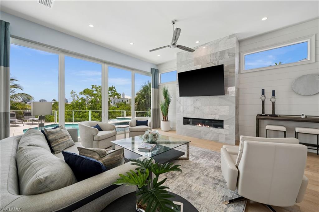 26659 Hickory Boulevard Bonita Springs, FL 34134 - Photo 12 of 46 a living room with furniture a fireplace and a flat screen tv