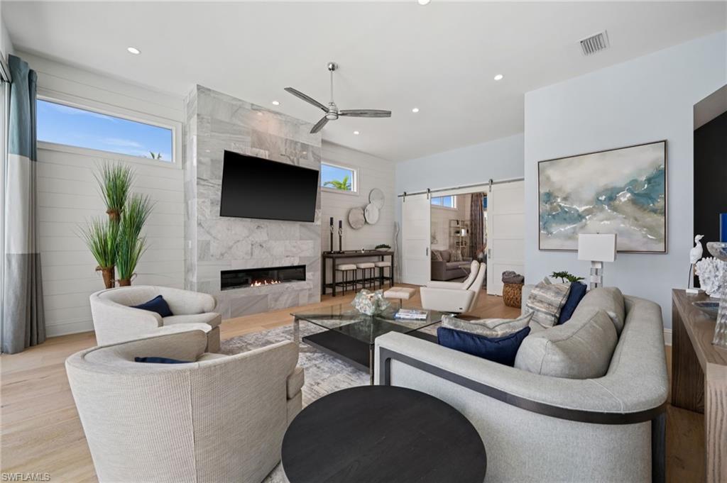 26659 Hickory Boulevard Bonita Springs, FL 34134 - Photo 14 of 46 a living room with furniture a flat screen tv and a fireplace