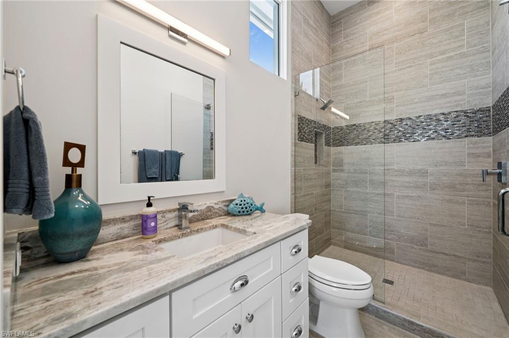 26659 Hickory Boulevard Bonita Springs, FL 34134 - Photo 26 of 46 a bathroom with a granite countertop toilet sink and mirror