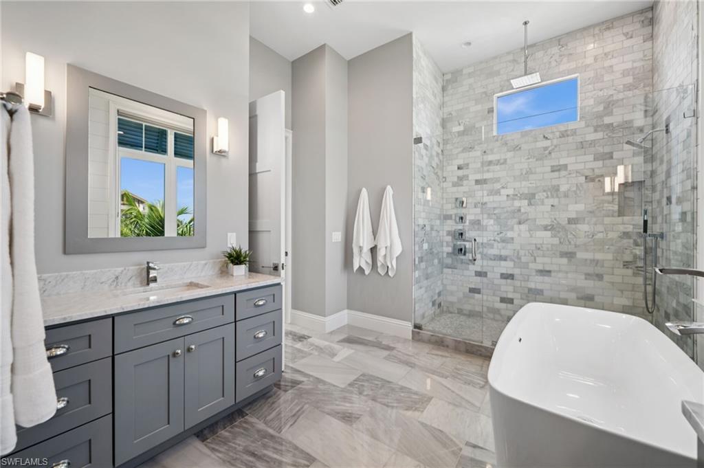 26659 Hickory Boulevard Bonita Springs, FL 34134 - Photo 33 of 46 a bathroom with a granite countertop sink a toilet a mirror and bathtub