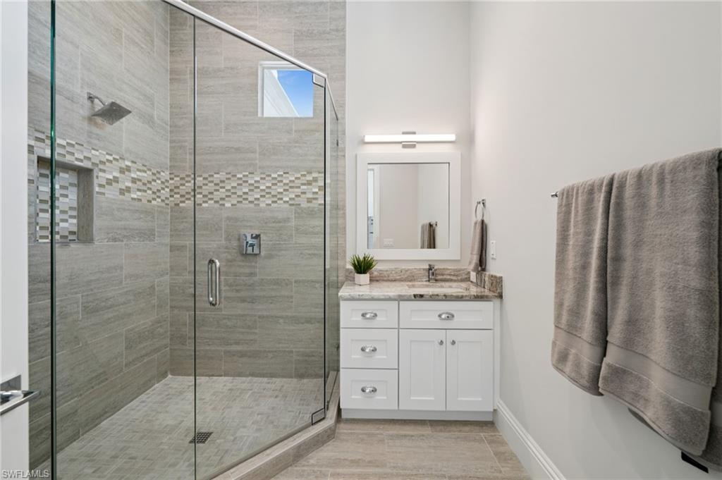 26659 Hickory Boulevard Bonita Springs, FL 34134 - Photo 37 of 46 a bathroom with a granite countertop sink a mirror and a shower