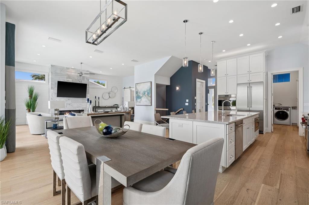 26659 Hickory Boulevard Bonita Springs, FL 34134 - Photo 6 of 46 a kitchen with stainless steel appliances a dining table chairs stove top oven and refrigerator
