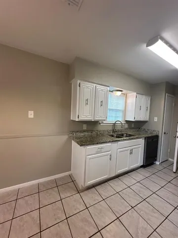 a kitchen with granite countertop sink and cabinets