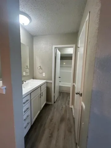 a spacious bathroom with a double vanity sink a toilet and a mirror