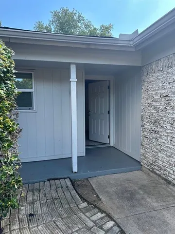 a view of backyard with potted plant and brick wall