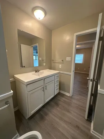 a room with a sink a mirror and a toilet