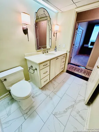 a bathroom with a toilet sink and mirror