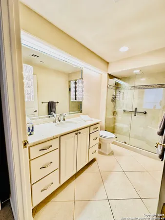 a spacious bathroom with a double vanity sink toilet and a mirror