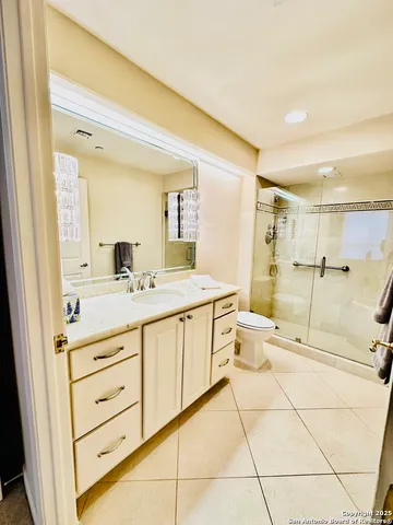 a spacious bathroom with a double vanity sink toilet and a mirror