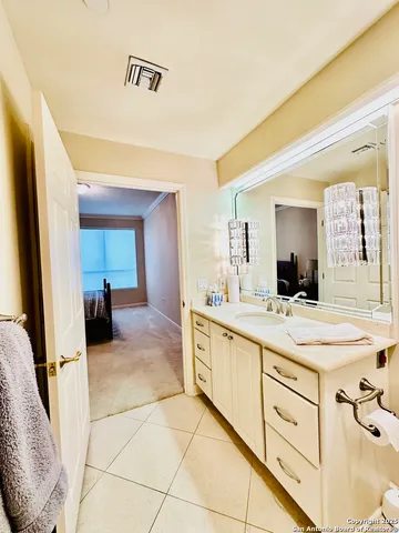 a spacious bathroom with a double vanity sink and a mirror