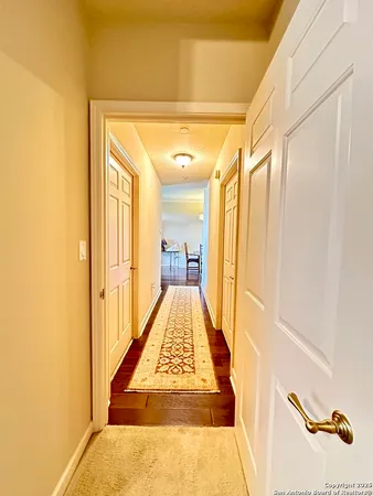 a view of a hallway with wooden floor and staircase