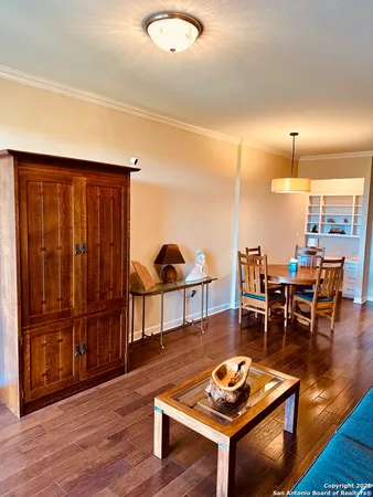 a living room with furniture a wooden floor and next to a window