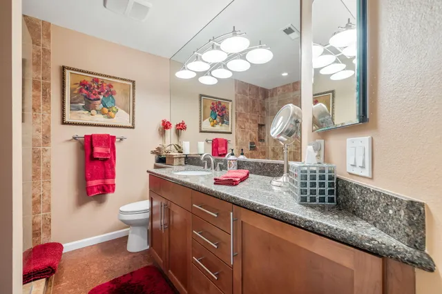a bathroom with a sink vanity mirror and toilet