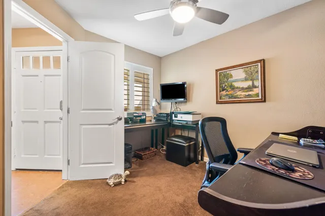 a view of a workspace with furniture and a window