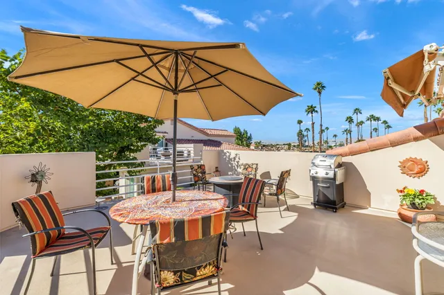 a patio with a table and chairs under an umbrella